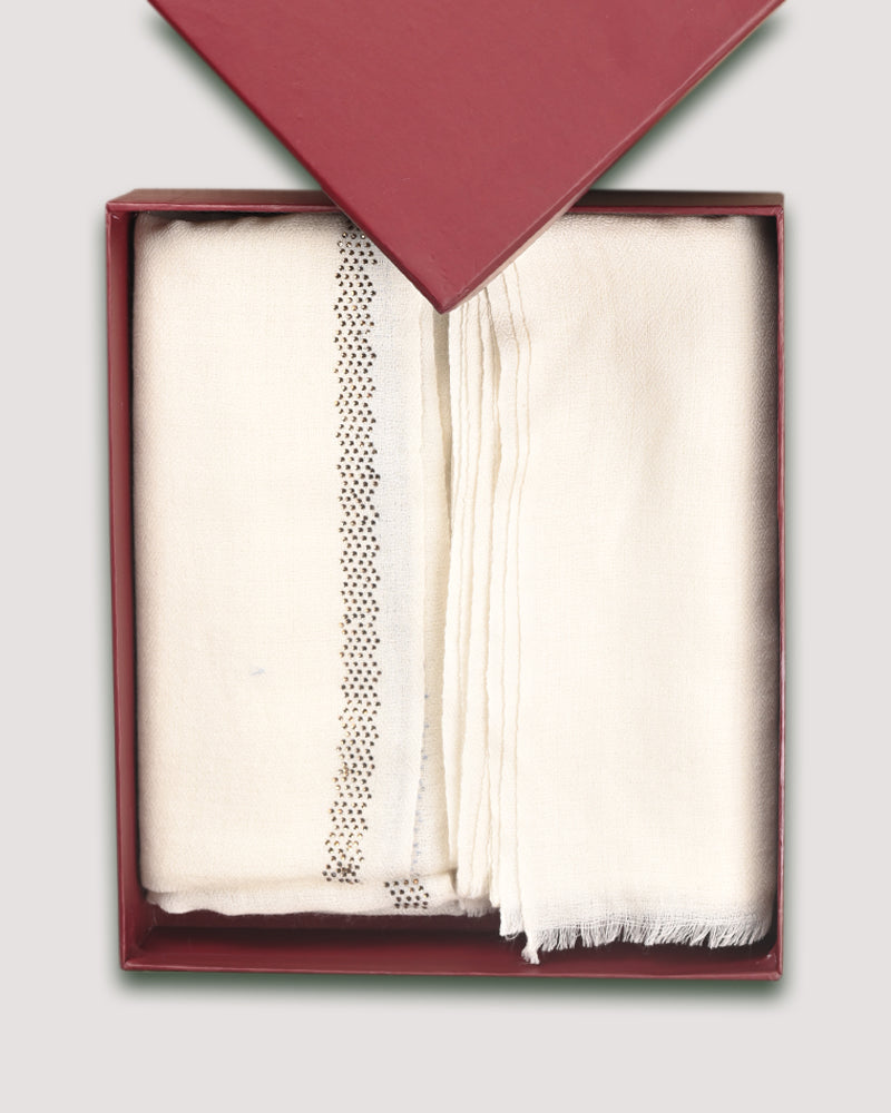 Two white wool-silk shawls with different patterns, one with a crystal border and the other with a diamond weave, presented in a red box.

